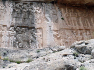 Rock relief near Bishapur, Iran, possibly portraying the response by Sasanian King Shapur II "The Great" of Iran, ca. 350 CE. Image acquired under CC-BY 3.0 license from user Pentocelo at Wikimedia Commons. Image cropped and color-corrected.